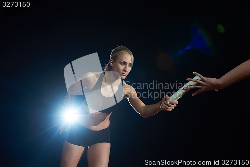 Image of athletic runners passing baton in relay race