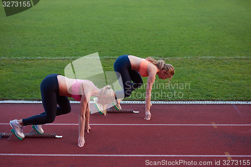 Image of athlete woman group  running on athletics race track