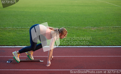 Image of woman  sprinter leaving starting blocks