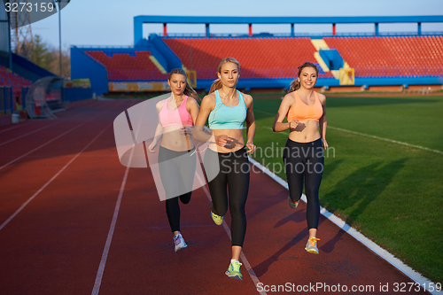 Image of athlete woman group  running on athletics race track