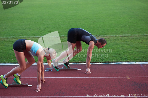 Image of athlete woman group  running on athletics race track