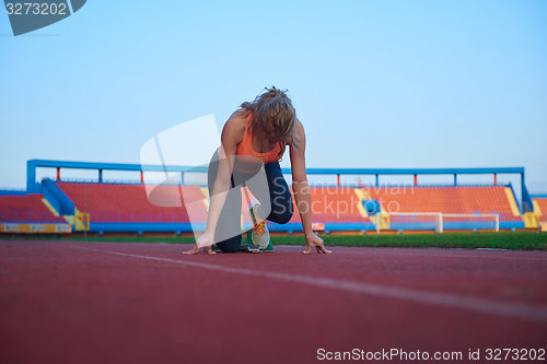 Image of woman  sprinter leaving starting blocks