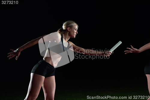 Image of athletic runners passing baton in relay race