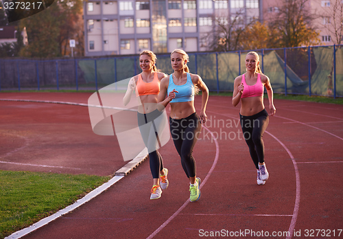 Image of athlete woman group  running on athletics race track