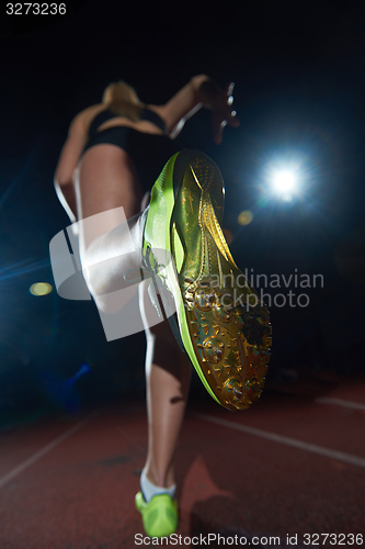 Image of woman  sprinter leaving starting blocks