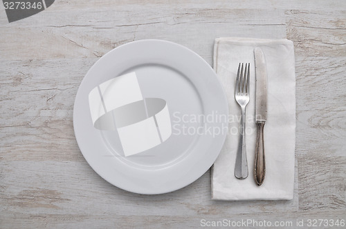 Image of Plate, cutlery and cloth on wood