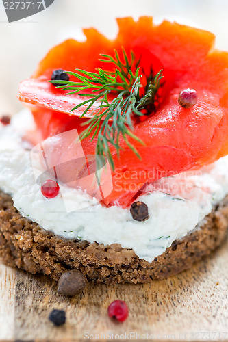Image of Sandwich with red salmon, cheese and dill.
