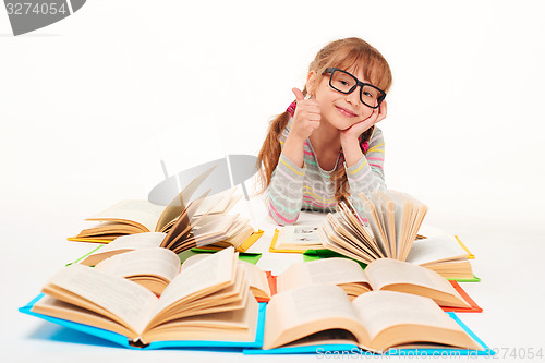 Image of Little girl sitting on floor with a lot of books