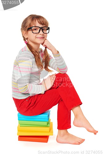 Image of Little girl sitting on floor with a lot of books