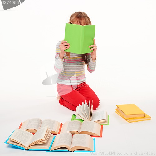 Image of Little girl sitting on floor with a lot of books