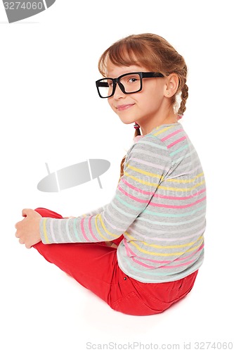 Image of Smiling little girl sitting on floor