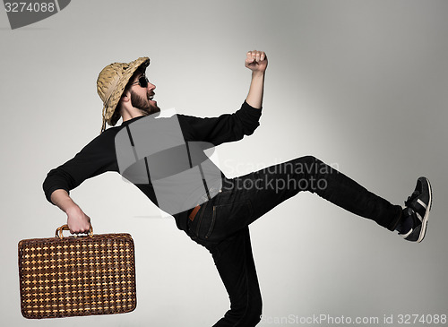 Image of Young, attractive man  in sunglasses with  suitcase ready to travel 