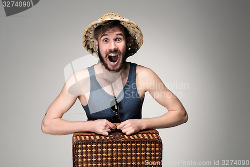 Image of Young, attractive man  in sunglasses with  suitcase ready to travel 