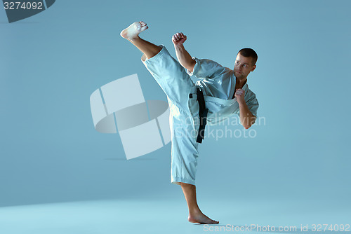 Image of Man in white kimono training karate