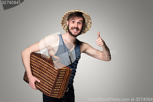 Image of Young, attractive man  in sunglasses with  suitcase ready to travel 