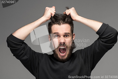 Image of frustration, man tearing hair out in anger