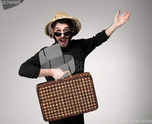 Image of Young, attractive man  in sunglasses with  suitcase ready to travel 