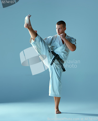 Image of Man in white kimono training karate