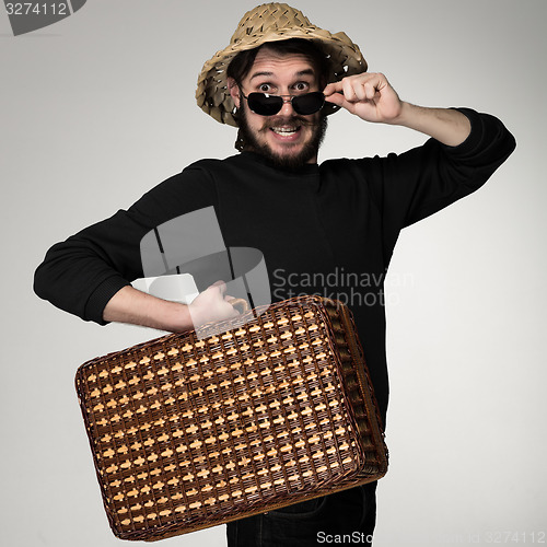 Image of Young, attractive man  in sunglasses with  suitcase ready to travel 