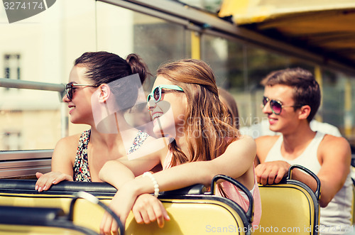 Image of group of smiling friends traveling by tour bus