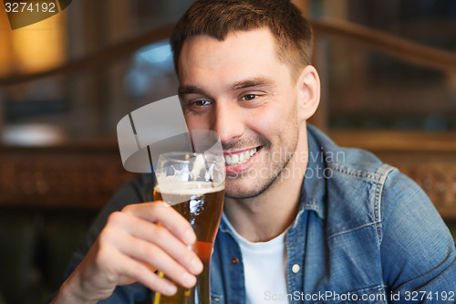 Image of happy man drinking beer at bar or pub