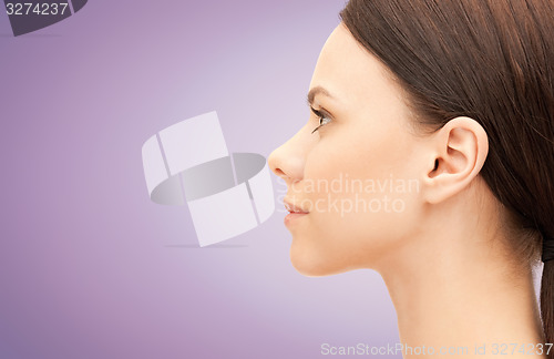 Image of beautiful young woman face over violet background