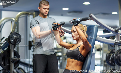 Image of man and woman flexing muscles on gym machine