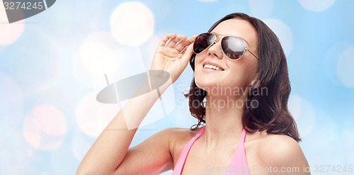 Image of happy woman in sunglasses and swimsuit