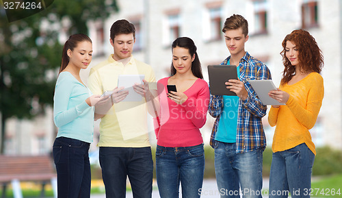 Image of group of teenagers with smartphones and tablet pc
