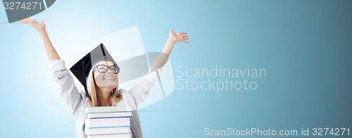 Image of happy student in mortar board cap with books