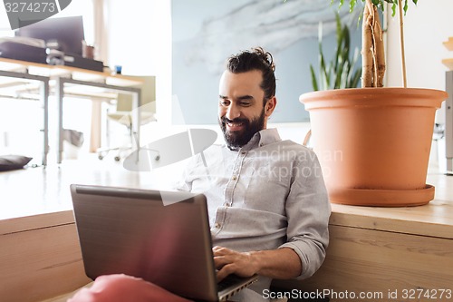 Image of happy creative male office worker with laptop