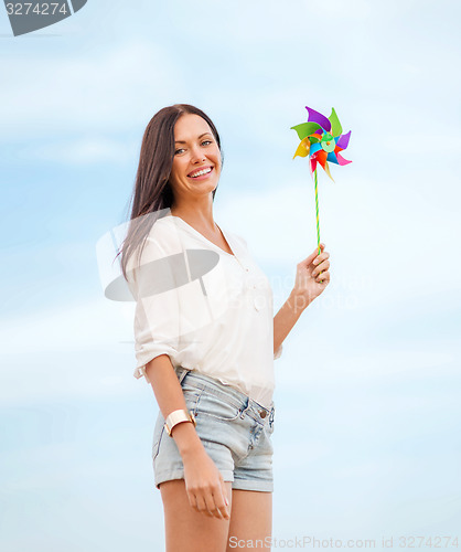 Image of girl with windmill toy on the beach