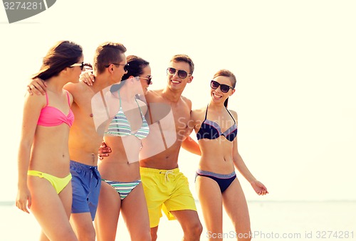 Image of smiling friends in sunglasses on summer beach