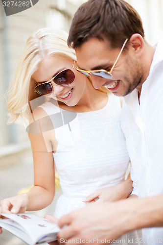 Image of couple with tourist book in the city