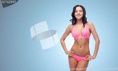 Image of happy young woman in pink bikini swimsuit