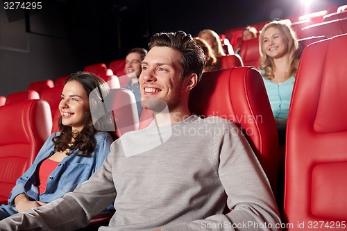 Image of happy friends watching movie in theater