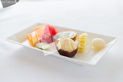 Image of plate of fresh juicy fruit dessert at restaurant