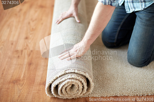 Image of close up of male hands rolling carpet