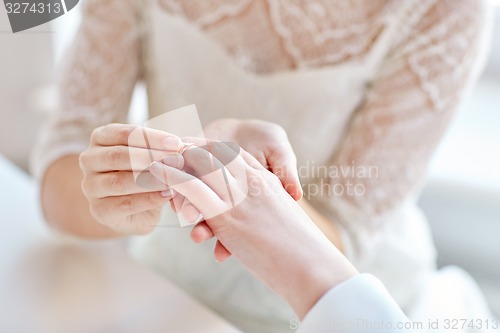 Image of close up of lesbian couple hands with wedding ring