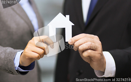 Image of businessman and businesswoman holding white house