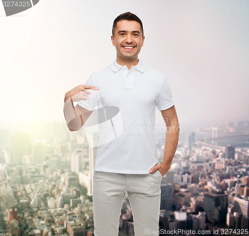 Image of smiling man in t-shirt pointing finger on himself