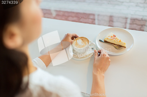 Image of close up of woman hands with cake and coffee