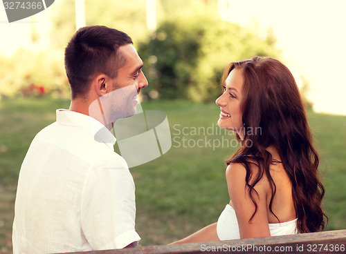 Image of smiling couple sitting on bench in park