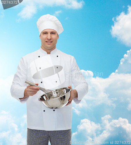 Image of happy male chef cook whipping something with whisk