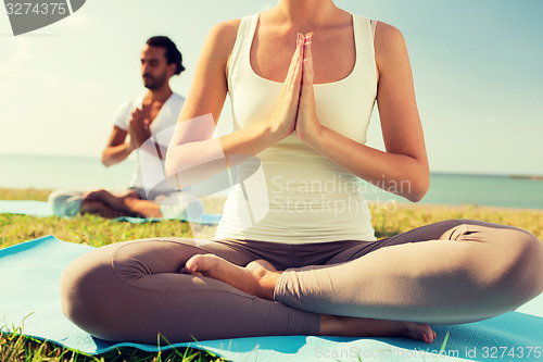 Image of close up of couple making yoga exercises outdoors