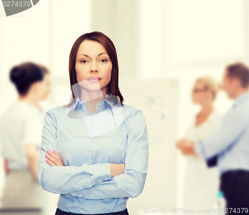 Image of smiling businesswoman with crossed arms at office