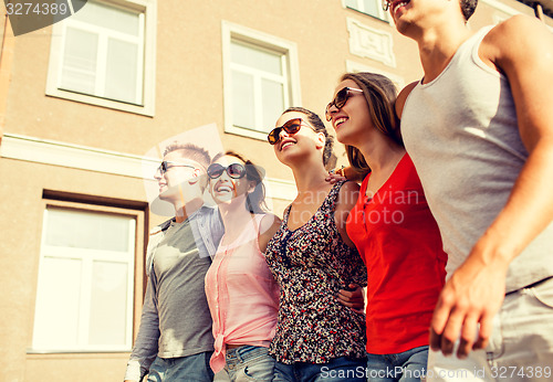 Image of group of smiling friends walking in city