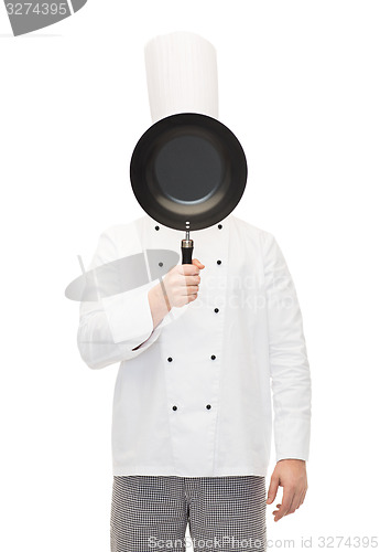 Image of male chef cook covering face with frying pan