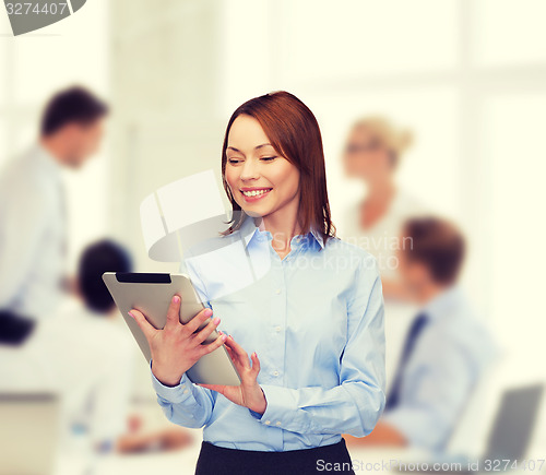 Image of smiling woman looking at tablet pc at office