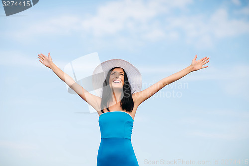 Image of girl with hands up on the beach